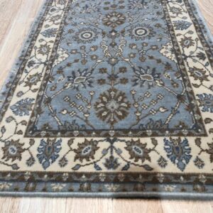 Traditional blue and beige runner rug with ornamental motifs sits on light-colored wood plank flooring.