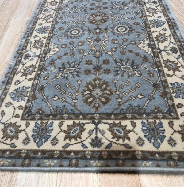 Traditional blue and beige runner rug with ornamental motifs sits on light-colored wood plank flooring.