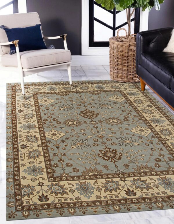 Dusty blue and cream traditional floral rug on white tile, framed by a beige armchair.