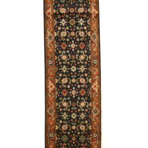 Black runner rug with an elaborate geometric floral pattern and a wide rust colored border.