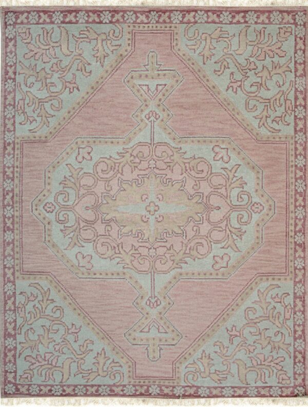 Rose and light blue rug featuring a traditional ornate central medallion and stylized floral borders.