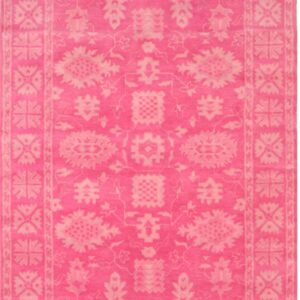 Bright pink rug featuring a monochromatic traditional floral and geometric border design.