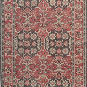 Low-pile rug with red, charcoal, and beige traditional floral patterns and visible fringe.