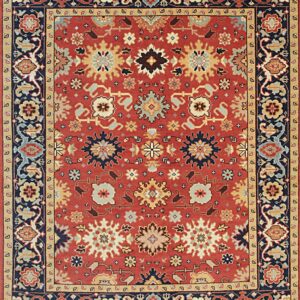 Rust red traditional rug with dense stylized florals and a complex navy and gold border.