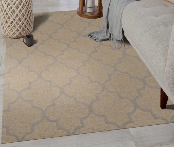 Beige rug featuring a gray trellis design partially under a sofa on light wood flooring.
