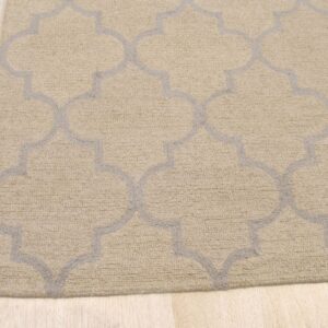 A looped beige rug with a gray Moroccan trellis pattern rests on pale wood flooring.
