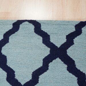 Light blue high-pile rug with a navy blue trellis pattern rests on natural wood flooring.