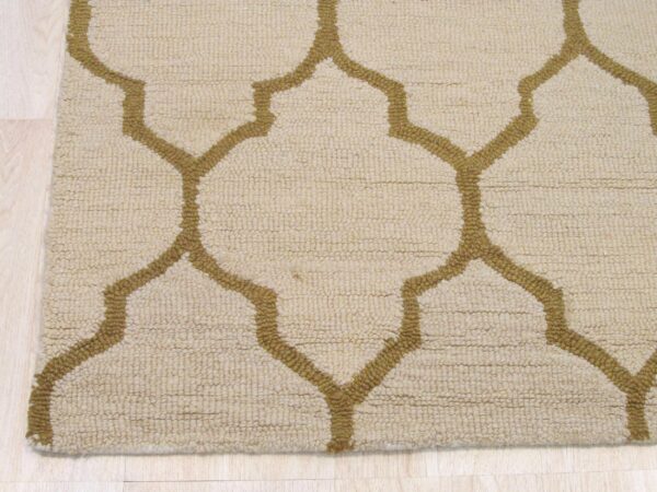 Beige looped rug featuring a thick mustard gold quatrefoil pattern on light wood plank flooring.