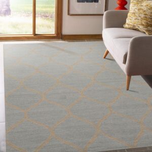 Blue-gray low-pile rug with a beige interlocking geometric pattern next to a light colored sofa.