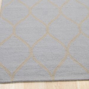 A textured light gray rug with a beige geometric trellis pattern lies on light wood flooring.