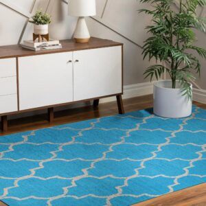 A bright blue rug with a beige geometric trellis pattern covers brown hardwood floors.