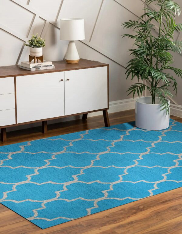 A bright blue rug with a beige geometric trellis pattern covers brown hardwood floors.