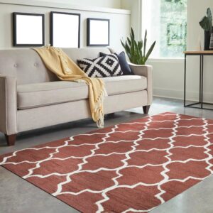 Low-pile terracotta rug with a white geometric lattice pattern anchors a brightly lit living room space.