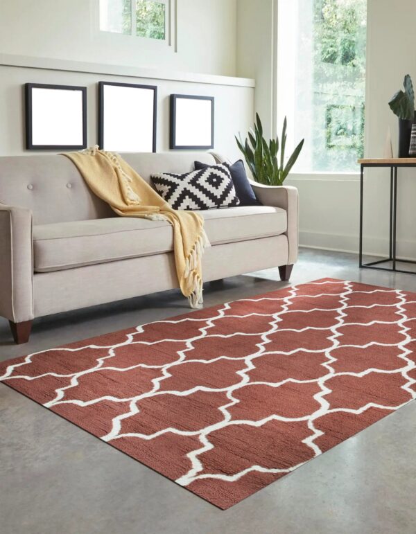 Low-pile terracotta rug with a white geometric lattice pattern anchors a brightly lit living room space.