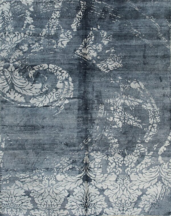 Distressed blue rug with faded white traditional floral and large damask patterns.