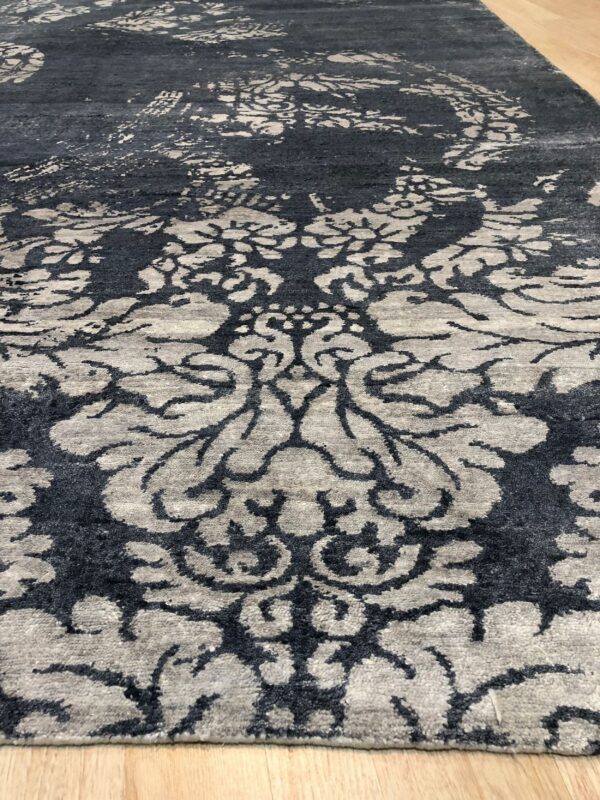 Gray high-low pile rug featuring a distressed damask pattern over light wooden flooring.