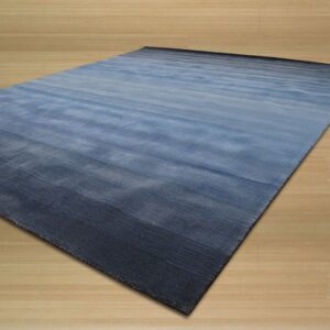 Blue rectangular rug featuring a horizontal gradient resting on light wood flooring.