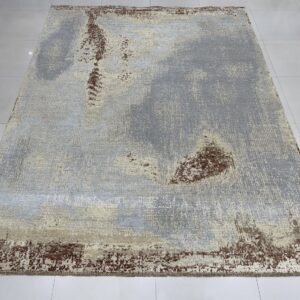 Rectangular rug with abstract gray, beige, and rust colors, laid on reflective white square tiles.