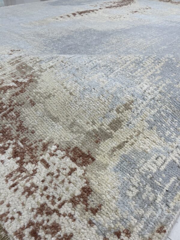Chunky pile rug featuring an abstract pattern in cream, light gray, and deep brown.