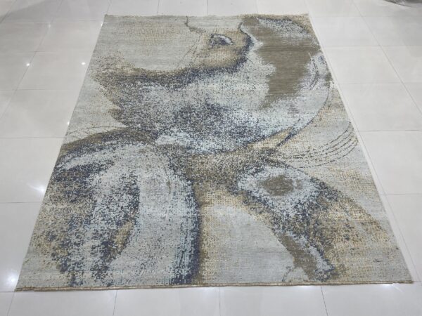 Abstract gray rug with swirling blue and gold distressed pattern on glossy white tile floor.