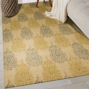 Yellow rug with alternating gold and sage medallion motifs sits next to a cream knit blanket.