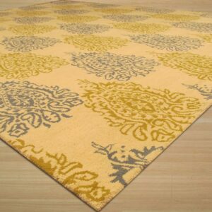 Yellow rug with alternating gray and olive medallions rests on light wood plank flooring.