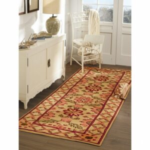 Floral runner in tan, red, and pink colors sits on dark wood floors beside a white cabinet.