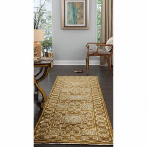 Gold and cream traditional runner rug extends down a dark wood hallway near a console table and chair.