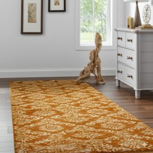 An ochre runner with a creamy floral pattern lies on dark wood flooring near a white chest of drawers.