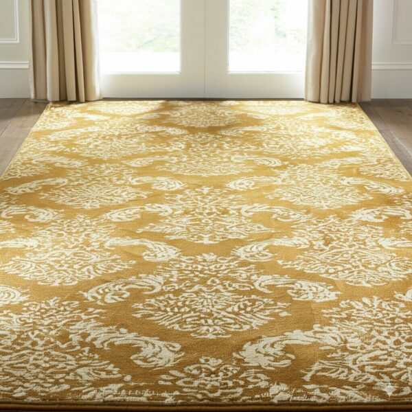 A high-contrast gold and cream rug with a distressed traditional pattern rests on dark wood flooring.
