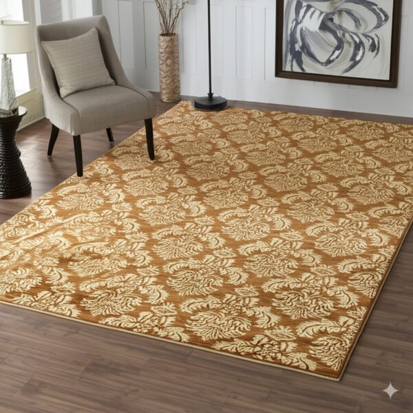 A rust-colored damask rug with cream floral patterns rests on dark wood flooring near a gray chair.