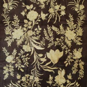 Dark brown rug featuring an elaborate, high-contrast pattern of gold floral sprays and scrolling leaves.