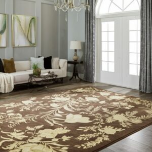 Brown and tan floral rug displayed on wood floors in a gray living room with a white couch.