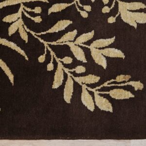 Dark brown rug featuring a raised tan floral pattern rests on light-colored wood planks.