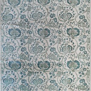 A detailed beige rug with a dense teal and sage floral and vine pattern.