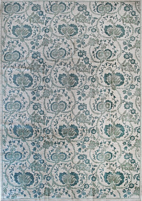 A detailed beige rug with a dense teal and sage floral and vine pattern.