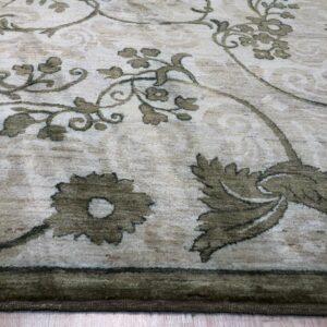 High-pile rug features an expansive olive green floral pattern over a mottled light beige background.