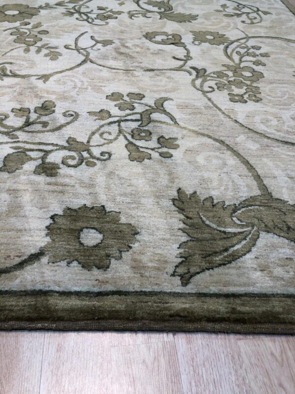 High-pile rug features an expansive olive green floral pattern over a mottled light beige background.