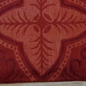 Tonal crimson and coral rug displaying a traditional floral medallion on light hardwood flooring.