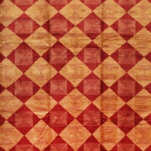 Low-pile rug patterned with repeating red and gold geometric diamonds featuring inner striped designs.