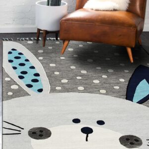 A gray bunny-shaped rug with polka dots and fringed edges rests under a brown leather chair.