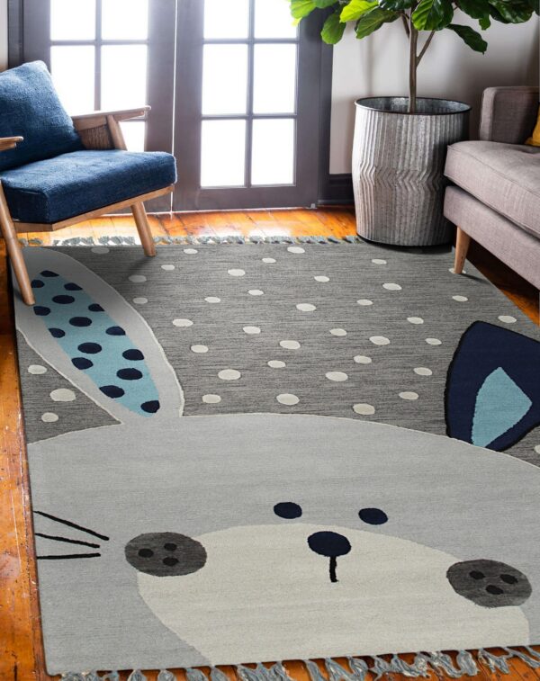 Gray polka dot rug featuring a large rabbit face with blue patterned ears on a hardwood floor.