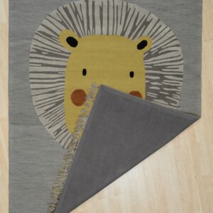 A gray rug featuring a yellow lion face pattern is partially folded back on pale wood floors.
