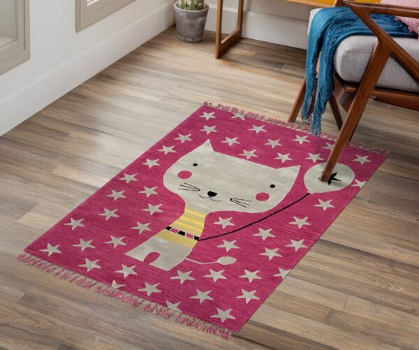 Low pile pink rug with a gray cat holding a balloon and scattered stars on a wood floor.