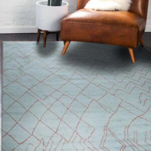 Light blue textured rug with an irregular red geometric pattern placed beneath a leather armchair.
