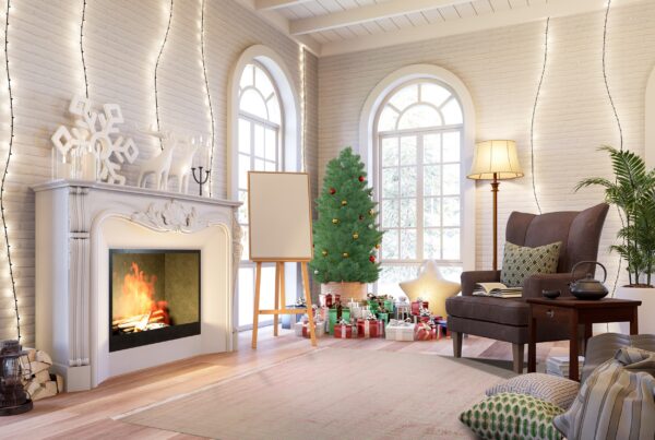 A muted, distressed pale pink rug sits on wood floors in a warmly lit holiday living room scene.