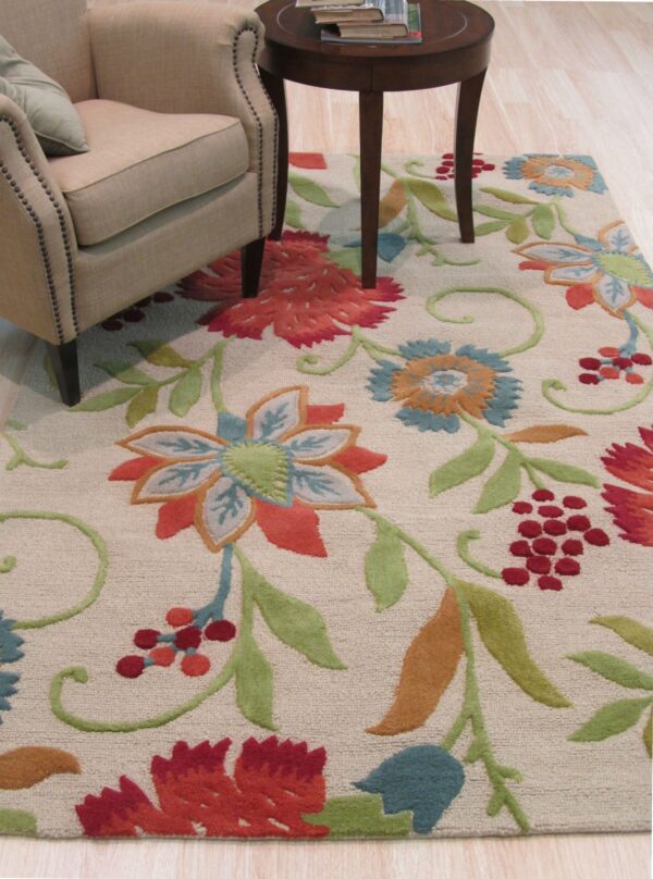 Colorful floral rug on a light wood floor next to a beige upholstered armchair.