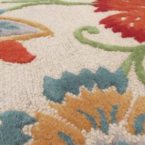 Detailed view of a rug showing raised floral designs in red, gold, teal, and a textured beige ground.