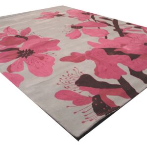 Modern cut pile area rug featuring large fuchsia floral blossoms and dark brown stems on a light gray background.