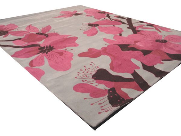Modern cut pile area rug featuring large fuchsia floral blossoms and dark brown stems on a light gray background.